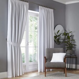 Dijon White Blackout Pencil Pleat Curtains Hanging In Room