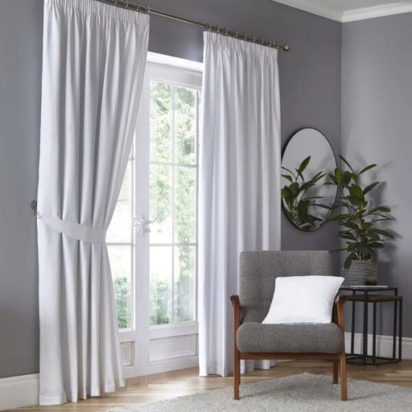 Dijon White Blackout Pencil Pleat Curtains Hanging In Room