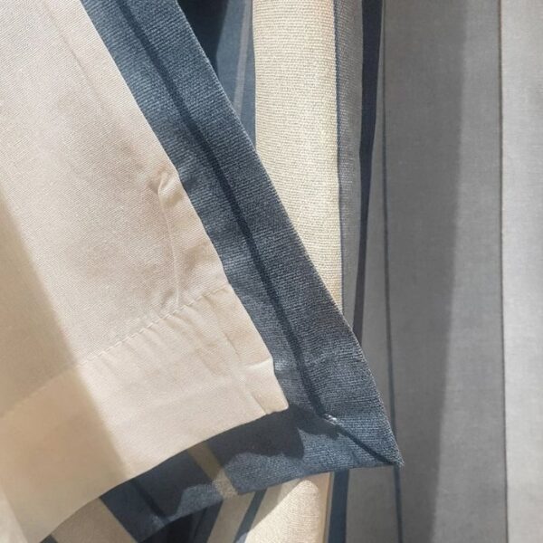 Close-up shows the striped fabric’s clean weave and sturdy eyelets. Great for casual modern spaces.