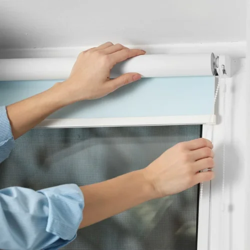 Person installing a roller blind on a window